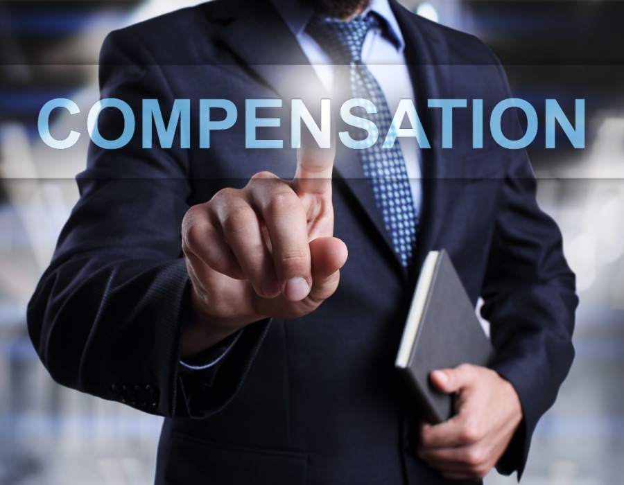 This is an image of a person in a suite with the word compensation in front of it.